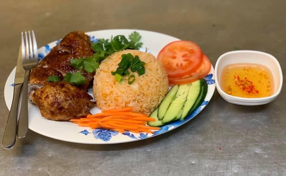 Vietnamese chicken and rice plate with nuoc cham, fresh vegetables and herbs
